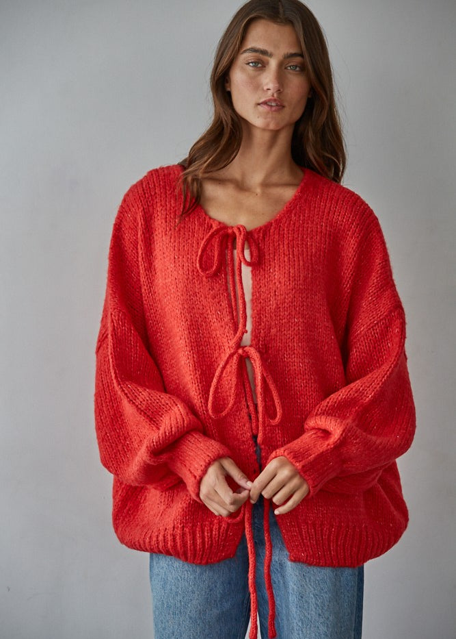 Woman wearing the Willow Boho Tie Cardigan, also known as the Sadie Tie Front Cardigan, in red — soft boho knit with tie-front closure and scoop neckline.