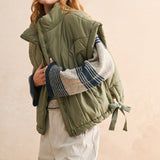Close-up of quilted nylon fabric on olive puffer vest — durable and soft material for everyday wear.